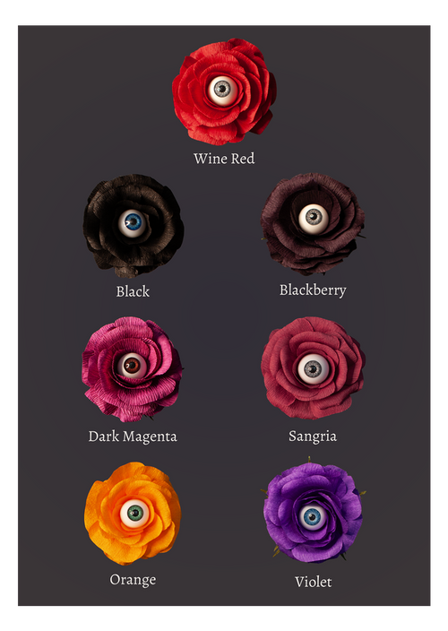 Eight artificial ranunculus-style flowers with realistic eyes in the center, arranged in two columns on a dark gray background. Each flower is labeled with a color name: Wine Red, Black, Blackberry, Dark Magenta, Sangria, Orange, Violet, and Purple.